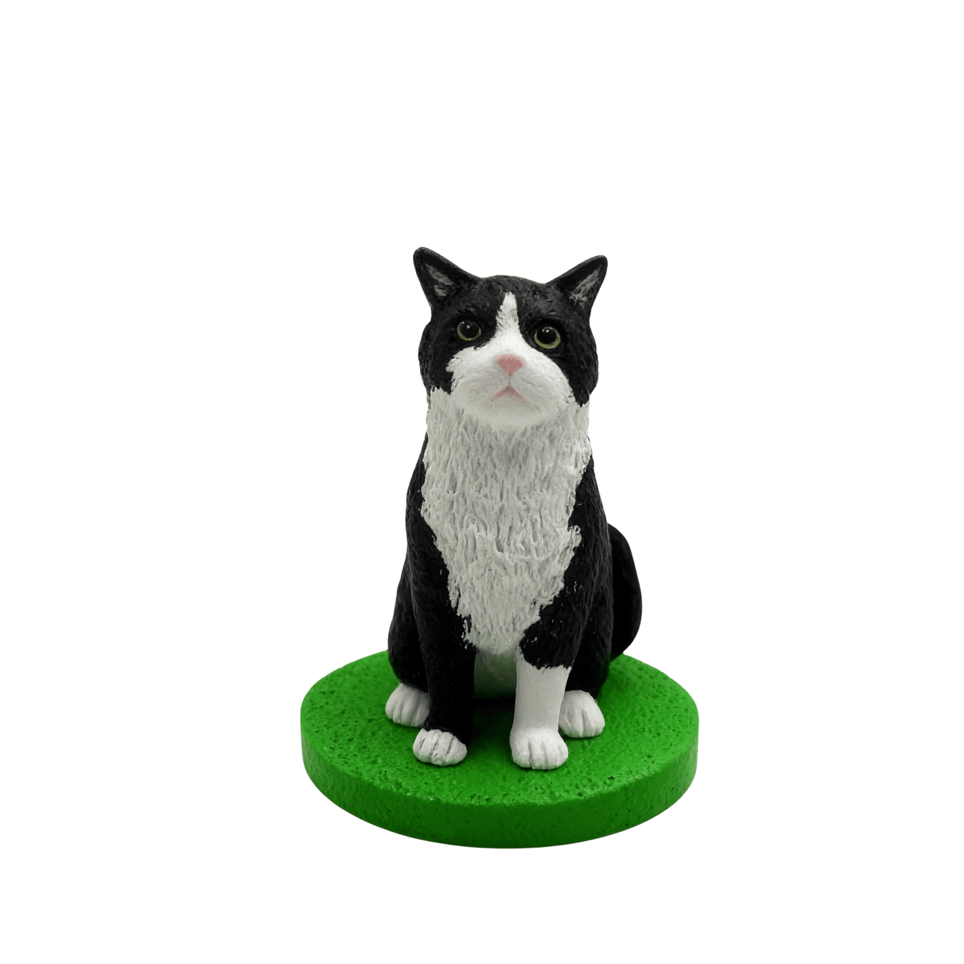 Black and white cat bobblhead figurine on a green base against a white background